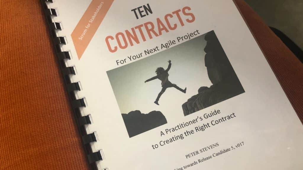 Książka - materiał promocyjny po konferencji: Ten Contracts for your Next Agile Project. A practicioner’s Guide to Creating the Right Contract. - Peter Stevens. Na okładce osoba przeskakująca przepaść.